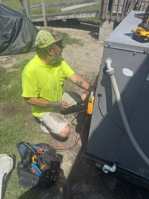 All About Air technician diagnosing a packaged AC unit with a meter