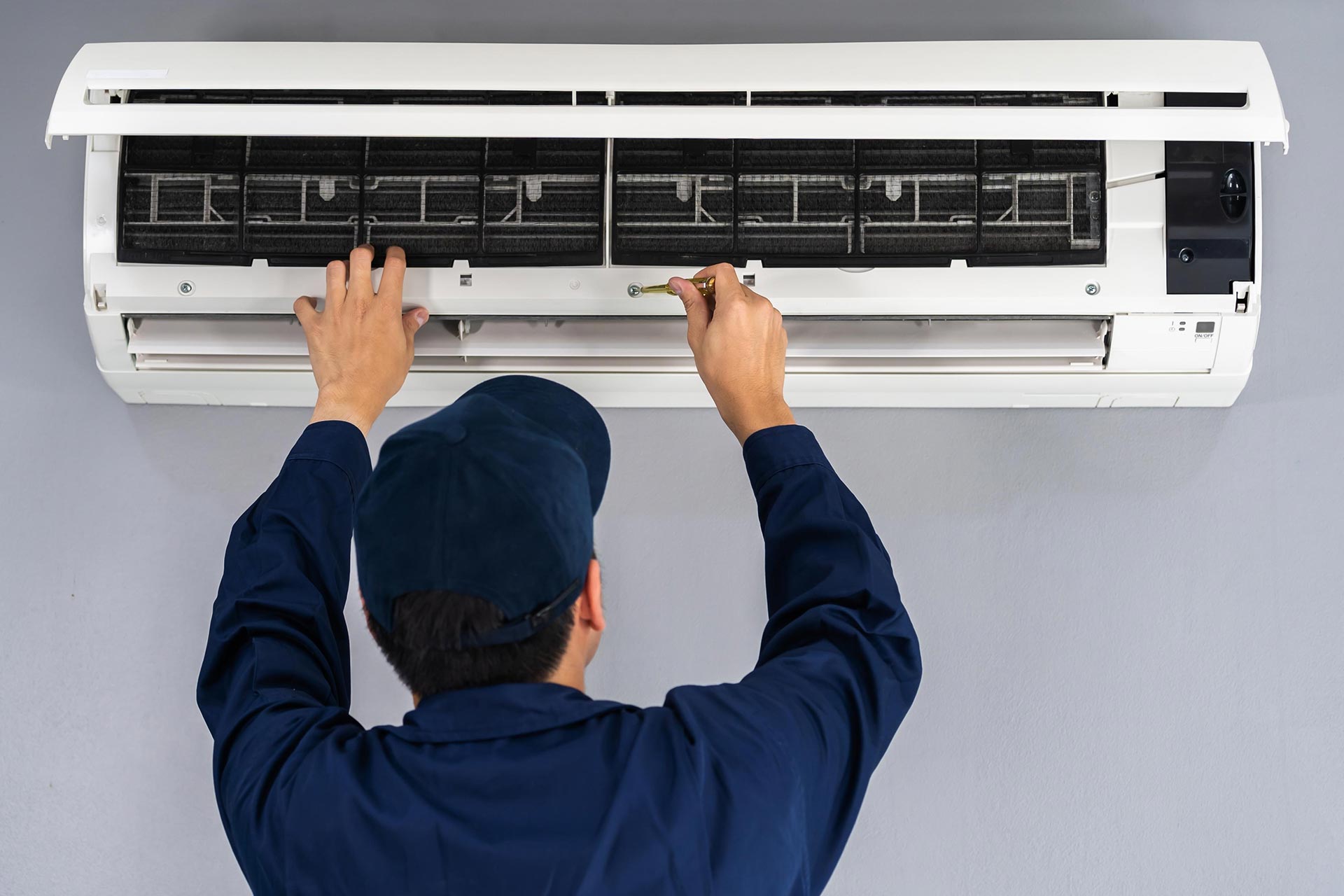 technician inspecting an AC unit
