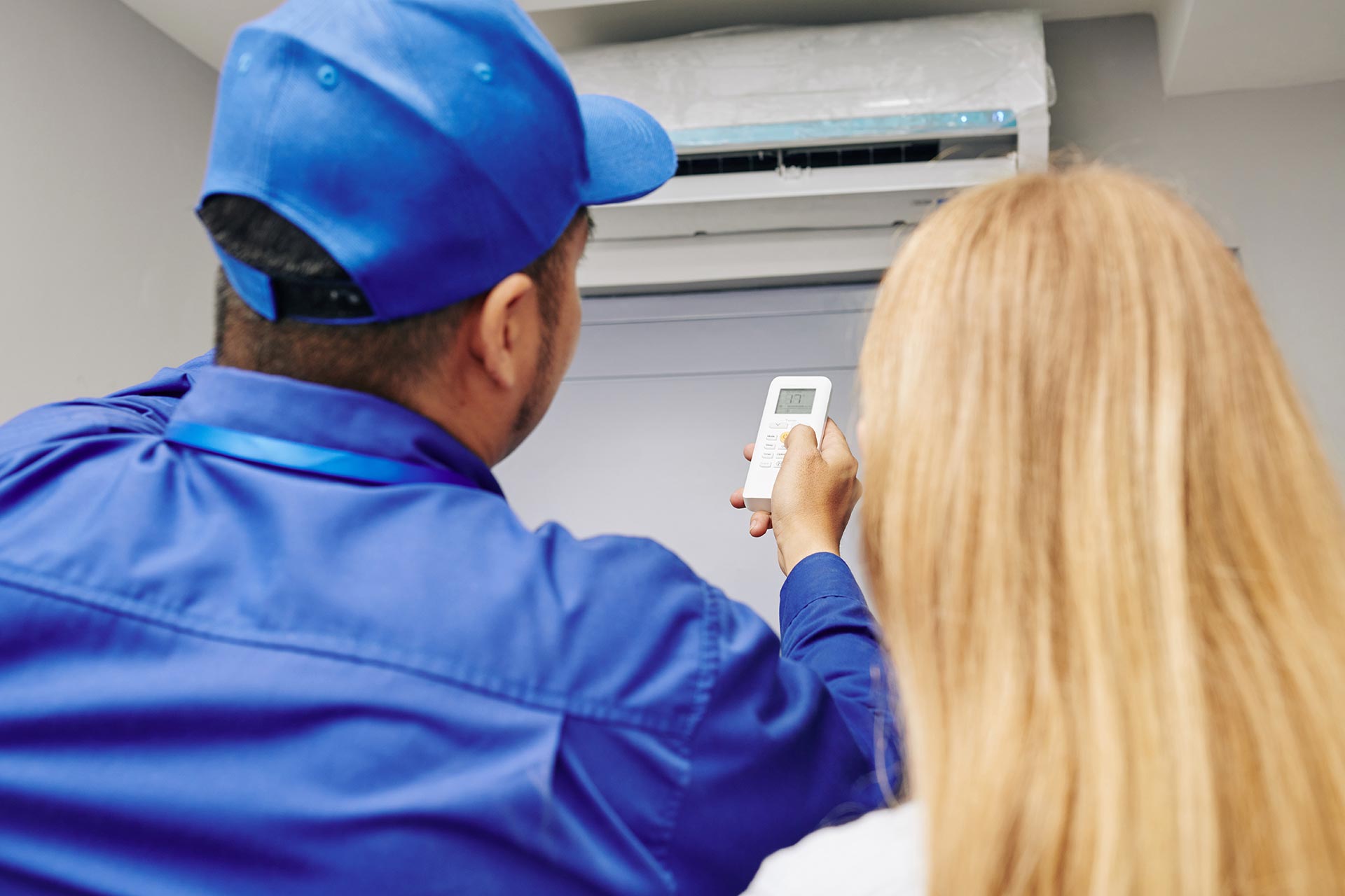 Worker checking air conditioner for functionality
