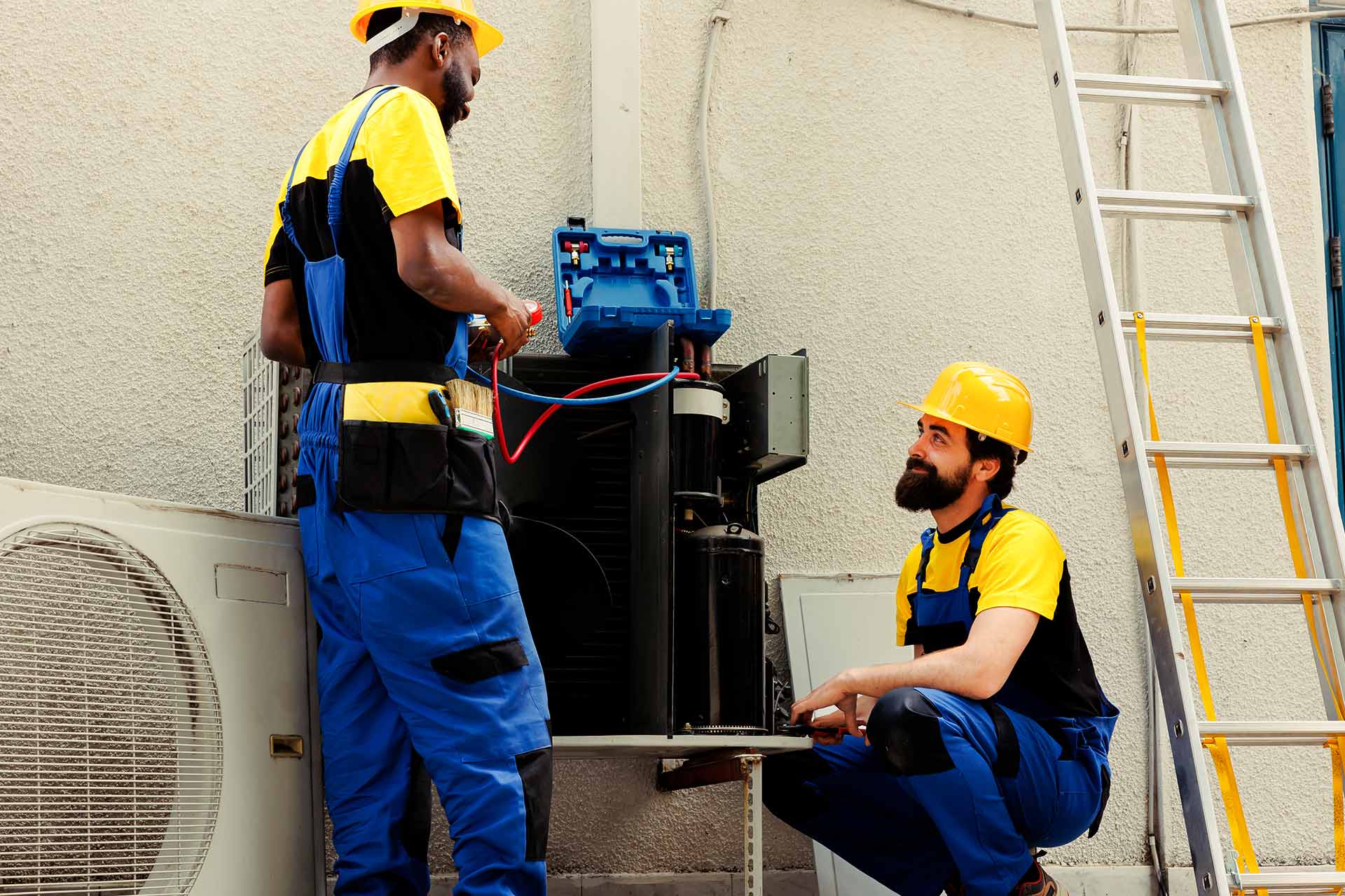 two technicians working on outdoor hvac unit